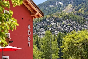 Un edificio rojo con el número 4061, rodeado de árboles y un paisaje montañoso.