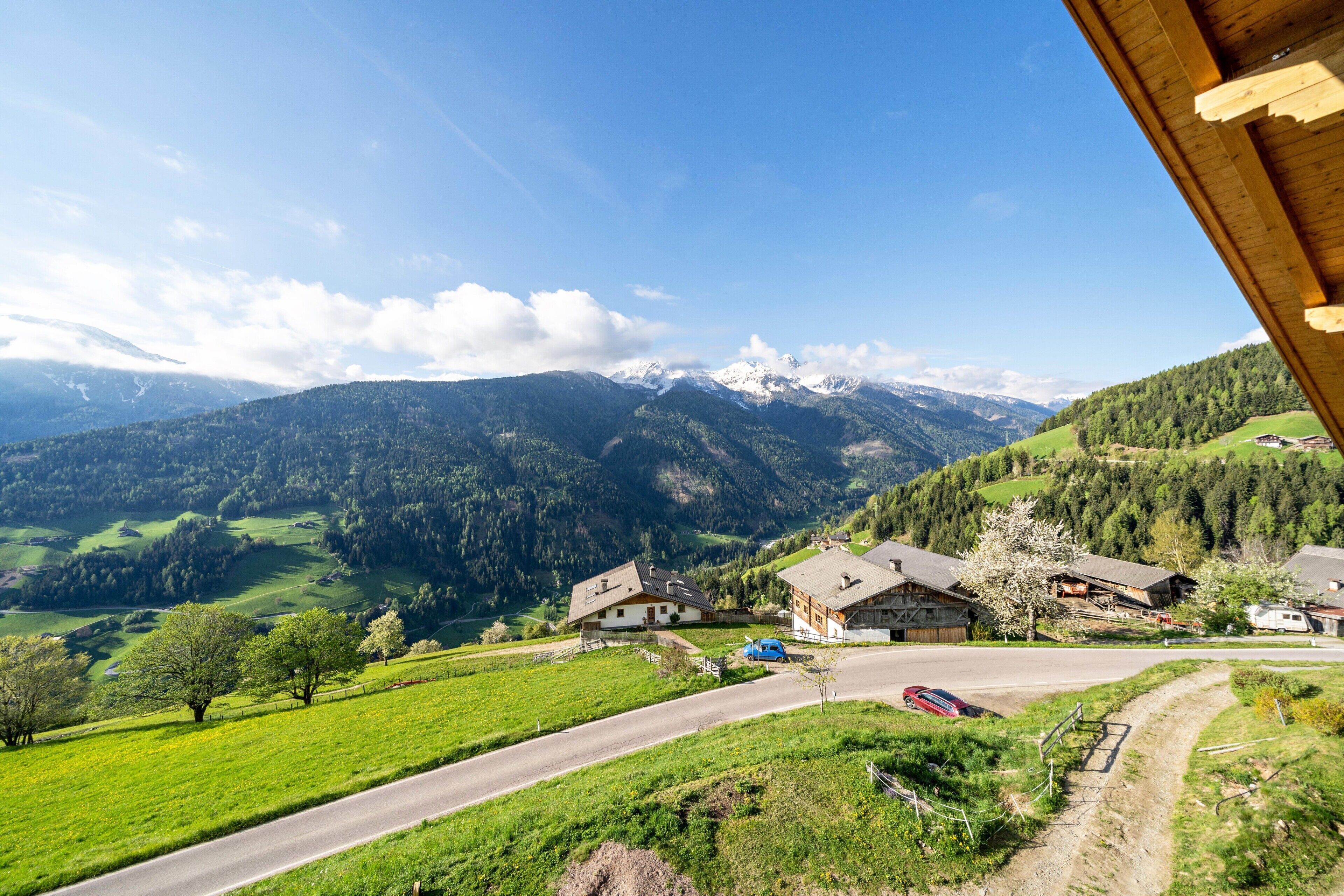 Paisaje rural con casas, una carretera y montañas al fondo.