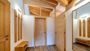 A hallway with wooden walls, a wooden bench, and a door. - Apartment 'Matscherhof Helena' with Mountain View, Shared Garden and balcony (St. Walburg)