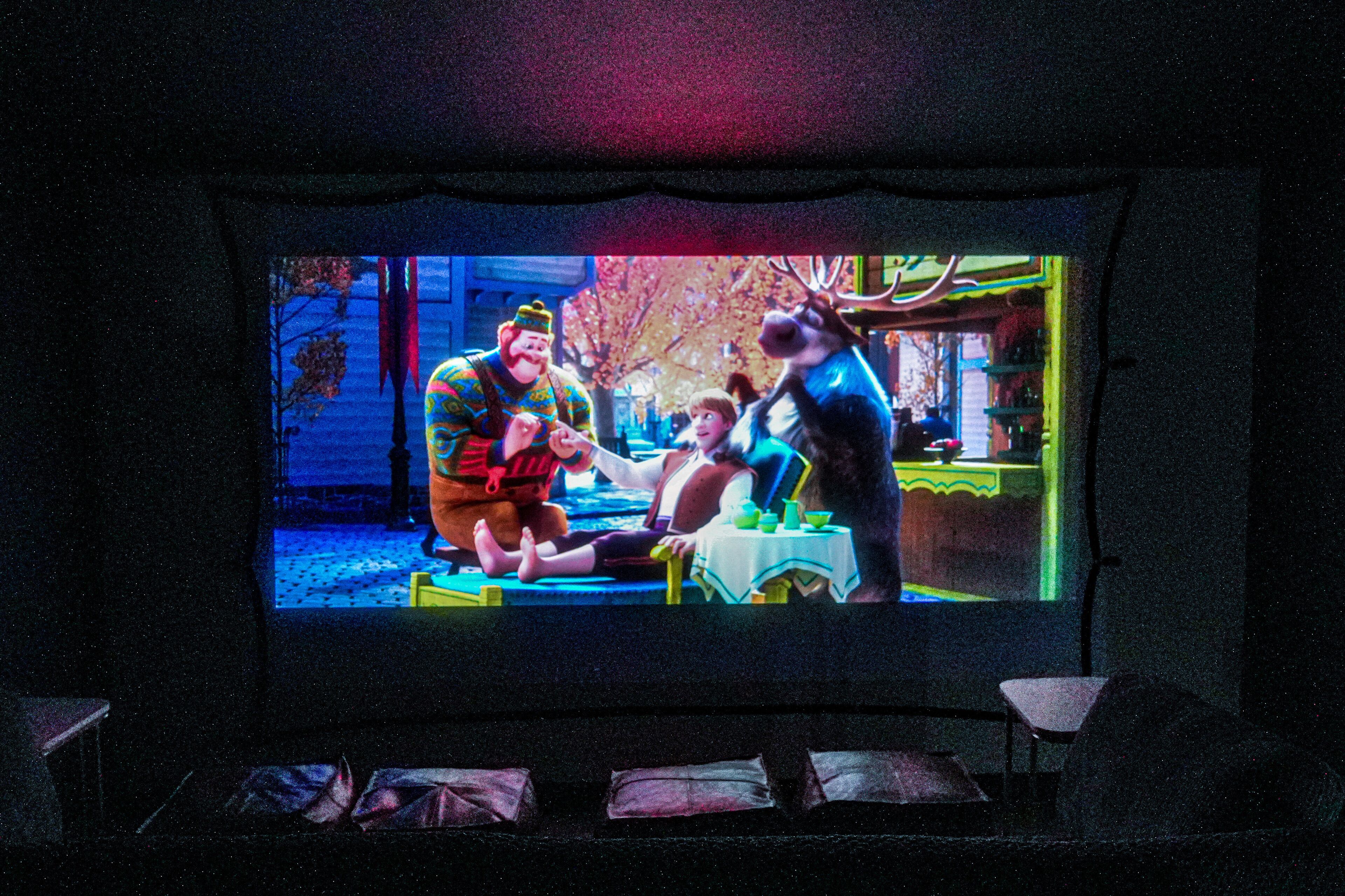 Un cine con una pantalla grande mostrando una escena de película.