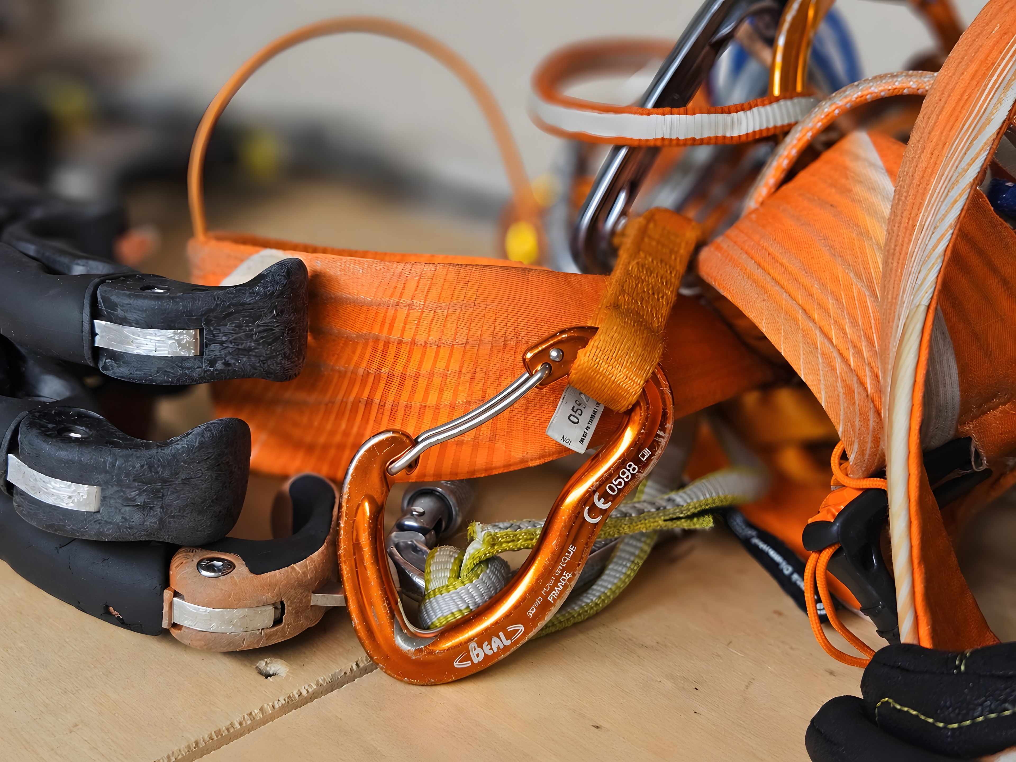 Een detailfoto van een klimharnas met metalen karabiners en banden.