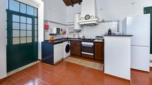 Eine Küche mit Waschmaschine, Backofen und Kühlschrank.