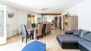 Ein Essbereich mit Tisch, Stühlen, einer Couch und einem Schrank.