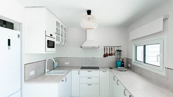 Cafetera o tetera, frigorífico, microondas y placa de cocina