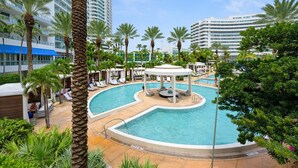 A pool area with a circular design, surrounded by palm trees and lounge chairs. - Direct Ocean View Studio at Sorrento Fontainebleau, Miami Beach (Miami Beach)