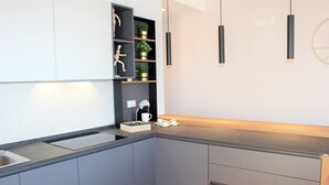 A modern kitchen with grey cabinets, a black countertop, and pendant lighting. - Apartment 'Gallipoli Waterfront' with Sea View, Balcony and Air Conditioning (Gallipoli)