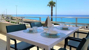 A table set for two with a view of the sea and a palm tree in the background. - Apartment 'Gallipoli Waterfront' with Sea View, Balcony and Air Conditioning (Gallipoli)