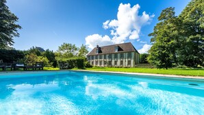 Una piscina con una casa sullo sfondo.