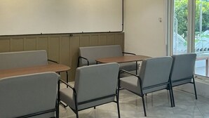 A modern waiting area with a high ceiling, recessed lighting, and a view of the outdoors through large windows. - Wisma Sanggrahan (Bantul)