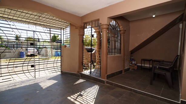 Un vaste espace intérieur doté d’un sol carrelé, d’un escalier et d’un coin salon avec un banc.