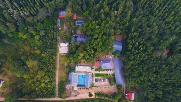 Vista aérea de un barrio residencial con varias casas, una piscina y un edificio rojo.