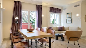 A dining area with a wooden table and chairs, a sofa, and a small coffee table.