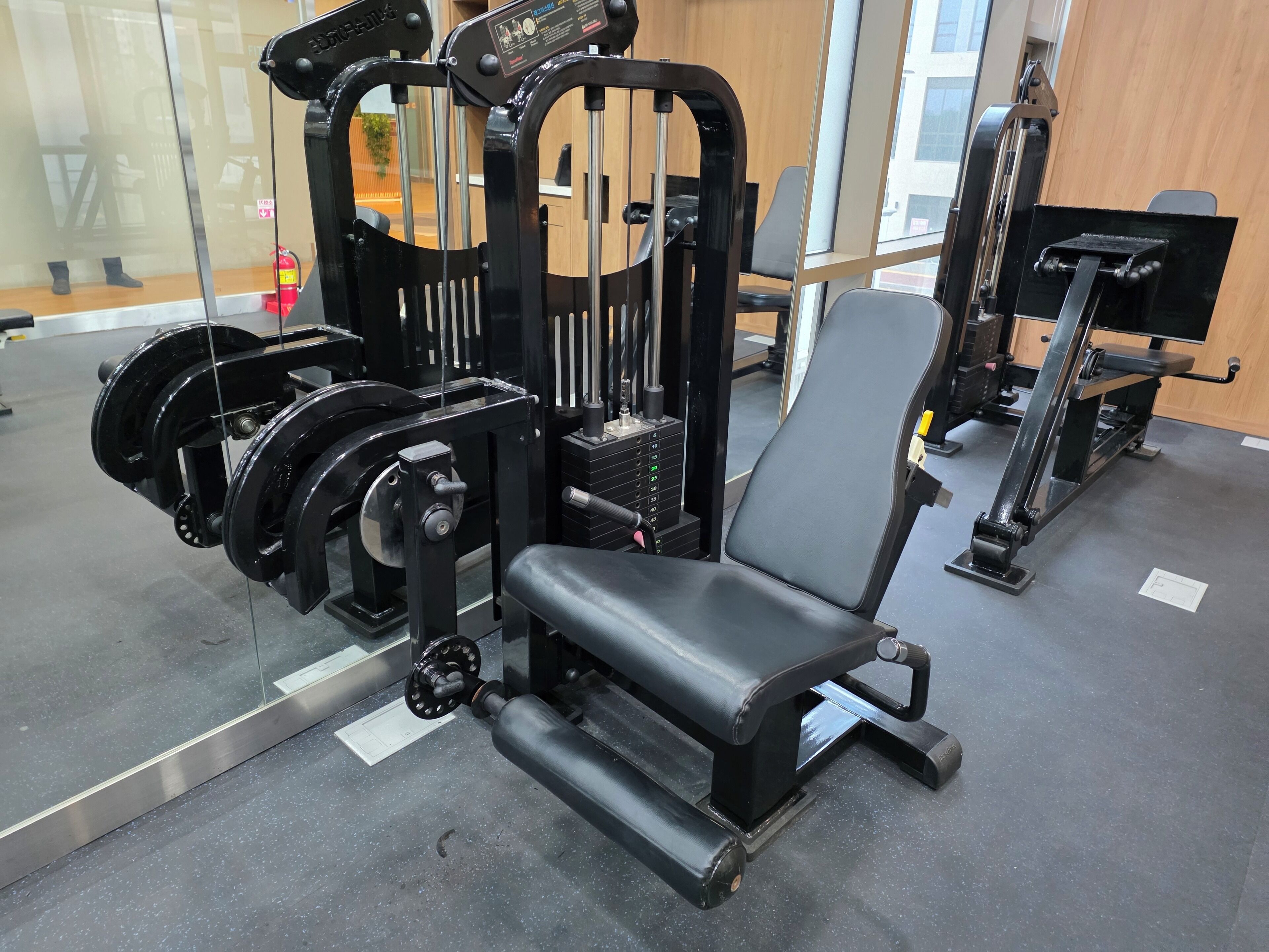 Une salle de sport équipée de matériel de musculation, notamment un banc de développé couché et un support à squats.