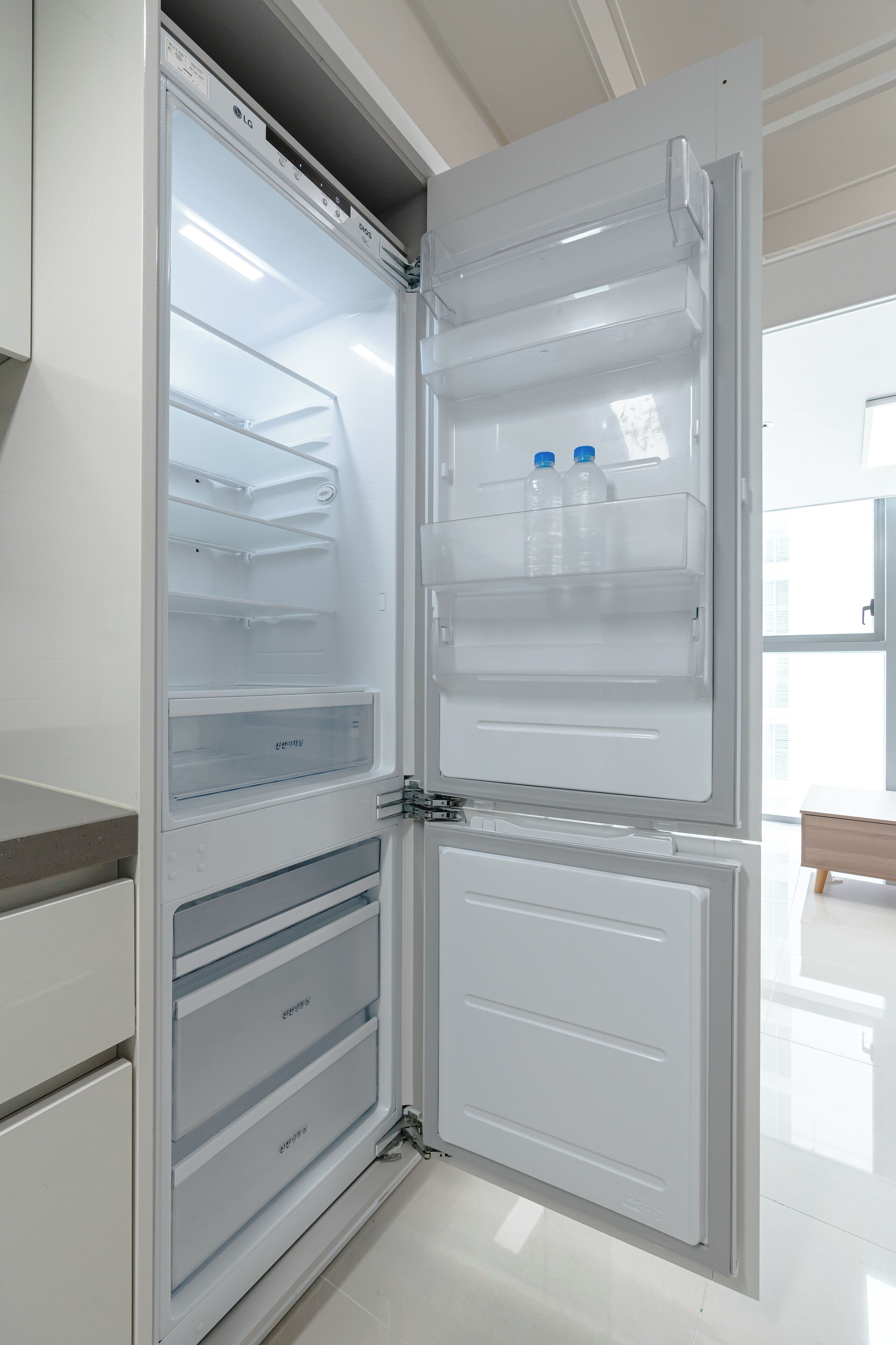 An open refrigerator with multiple shelves and drawers, and a small window at the top.