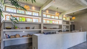 A modern kitchen with concrete countertops, built-in shelves, and pendant lighting. - Ubud Terrace by Betterplace (Ubud)