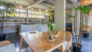 A spacious dining area with a wooden table, wicker chairs, and potted plants. - Ubud Terrace by Betterplace (Ubud)