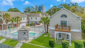 A residential area with houses, a pool, and a clear sky. - 2185 Sanibel Court (Myrtle Beach)