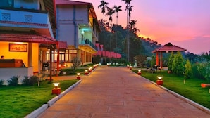 A hotel pathway with a view of the surrounding landscape and a gazebo. - Hill Crest Resort (Madikeri)