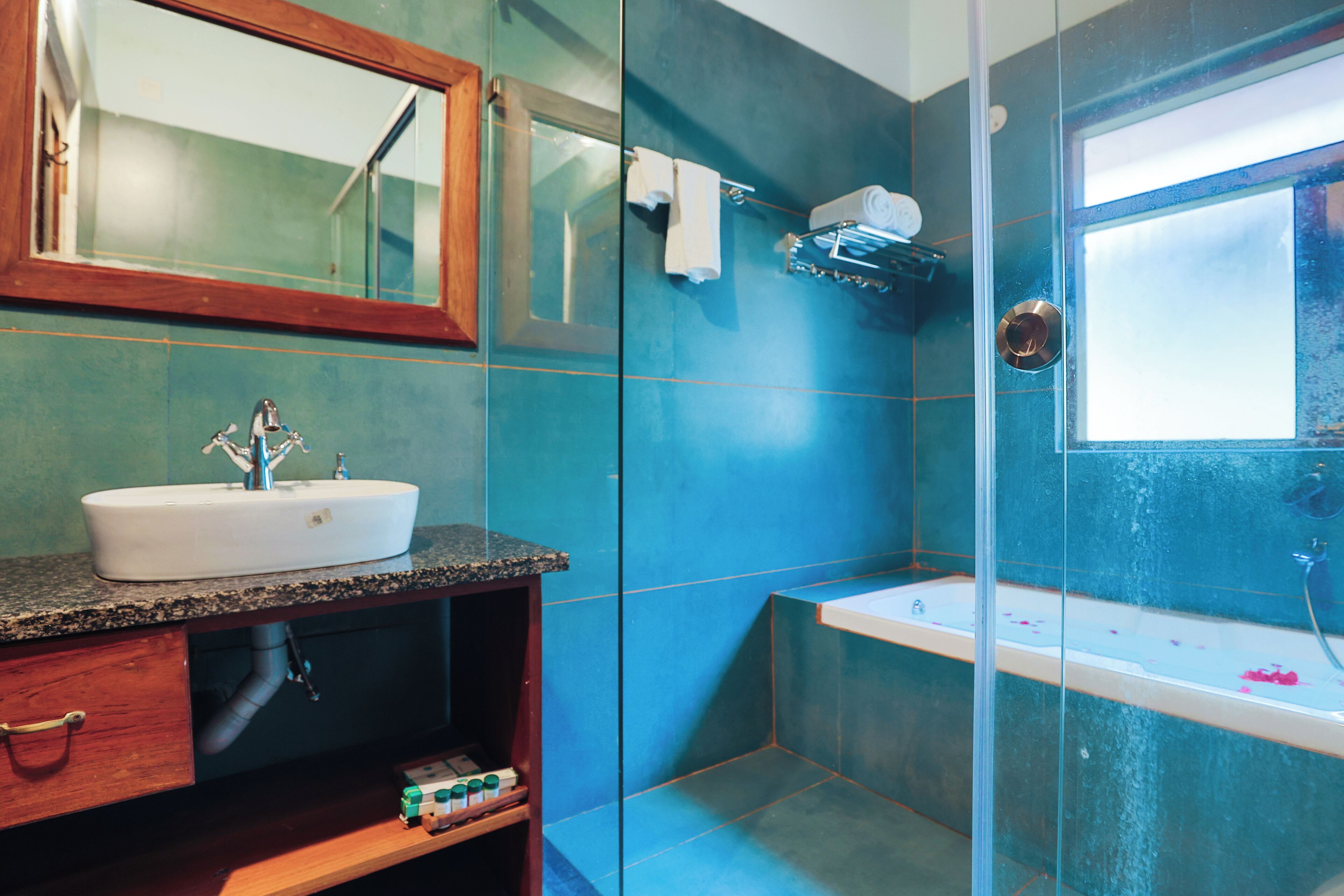Un baño con un lavamanos blanco, un espejo y una bañera.