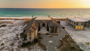 A beachfront property with a central building, a circular driveway, and adjacent structures. - "Beach Castle" | Private Beachfront home with heated pool, ping pong & pool table! (Santa Rosa Beach)