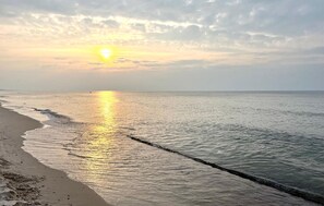 Ein Strand mit ruhiger See und Sonnenuntergang.
