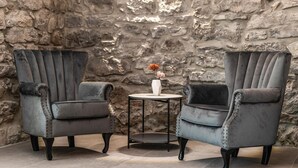 Two grey upholstered armchairs with metal studs, a small round table, and a vase with flowers. - Gorgeous home in Lakmartin (Lakmartin)