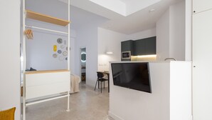 A modern kitchen with a flat-screen TV, a microwave, and a built-in oven. - The Sorolla Apartment V | AC & WiFi | 4 Guests (Valencia)