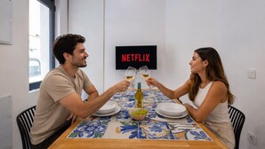 Une table à manger avec un téléviseur en arrière-plan affichant le logo « NETFLIX ».