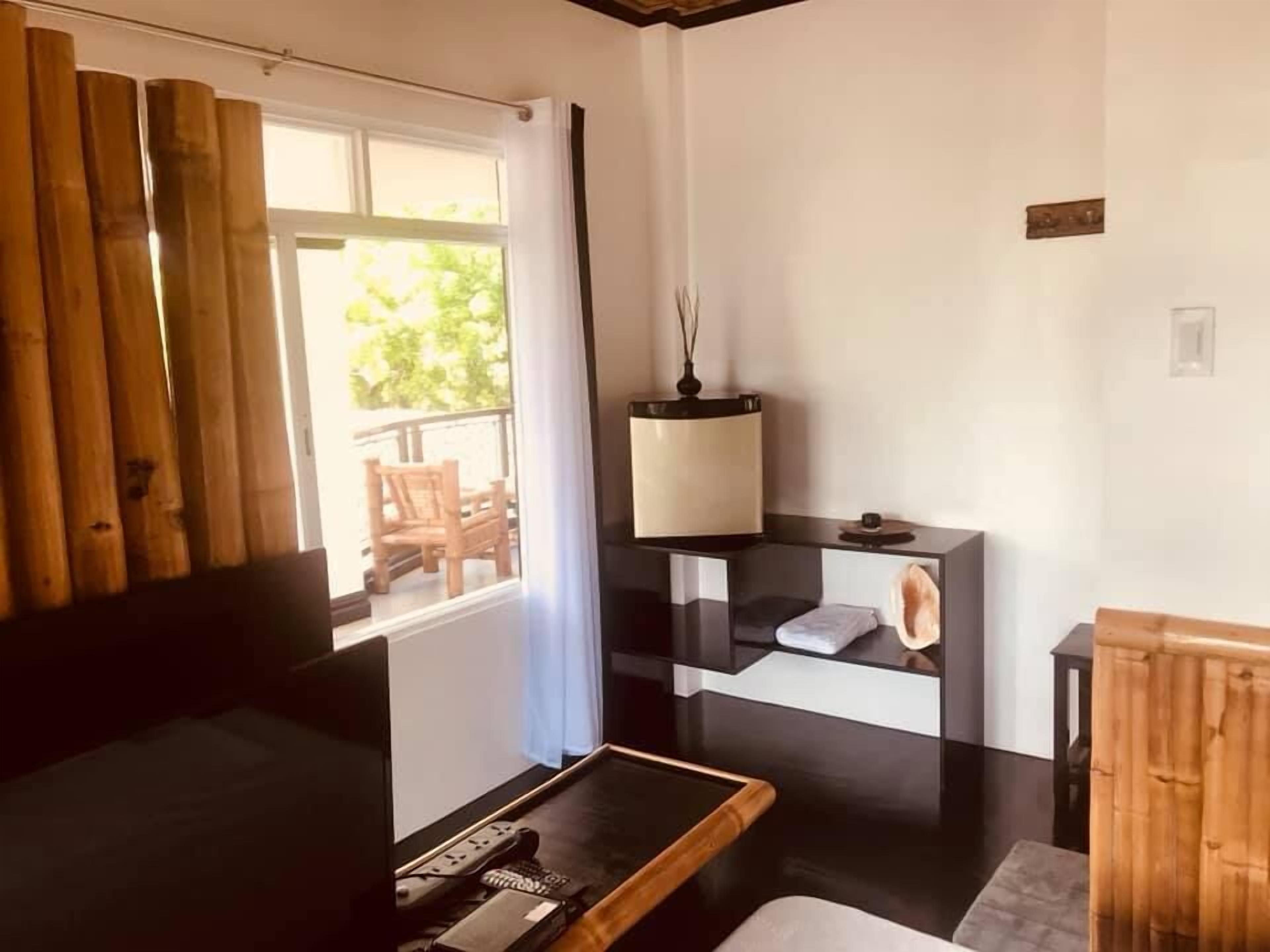 Una habitación moderna con un escritorio de madera, una lámpara y vistas al exterior.