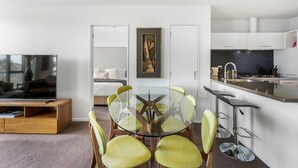 A modern kitchen with white cabinets, a black backsplash, and a stainless steel sink. - Kingsland, Auckland 2BR 2Bath 2CarPark Apt (Auckland)