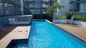 A modern indoor swimming pool with wooden decking and lounge chairs. - Kingsland, Auckland 2BR 2Bath 2CarPark Apt (Auckland)