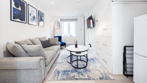 Ein modernes Wohnzimmer mit einer Couch, einem Couchtisch und Kunstwerken an der Wand.