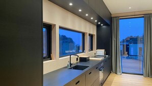 A modern kitchen with a large window, built-in oven, and a view of the city. - 3 bedroom lovely home in Lindesnes (Lindesnes)