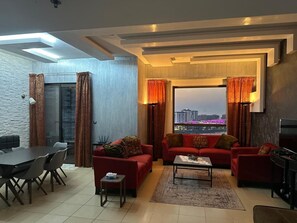 Relax in a spacious living room with a city view, perfect for socializing or dining.