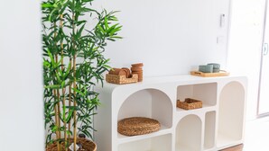 A white console table with woven baskets and a potted bamboo plant. - Pet Paradise w/ Fenced yard & close to Beach (Ocean Grove)