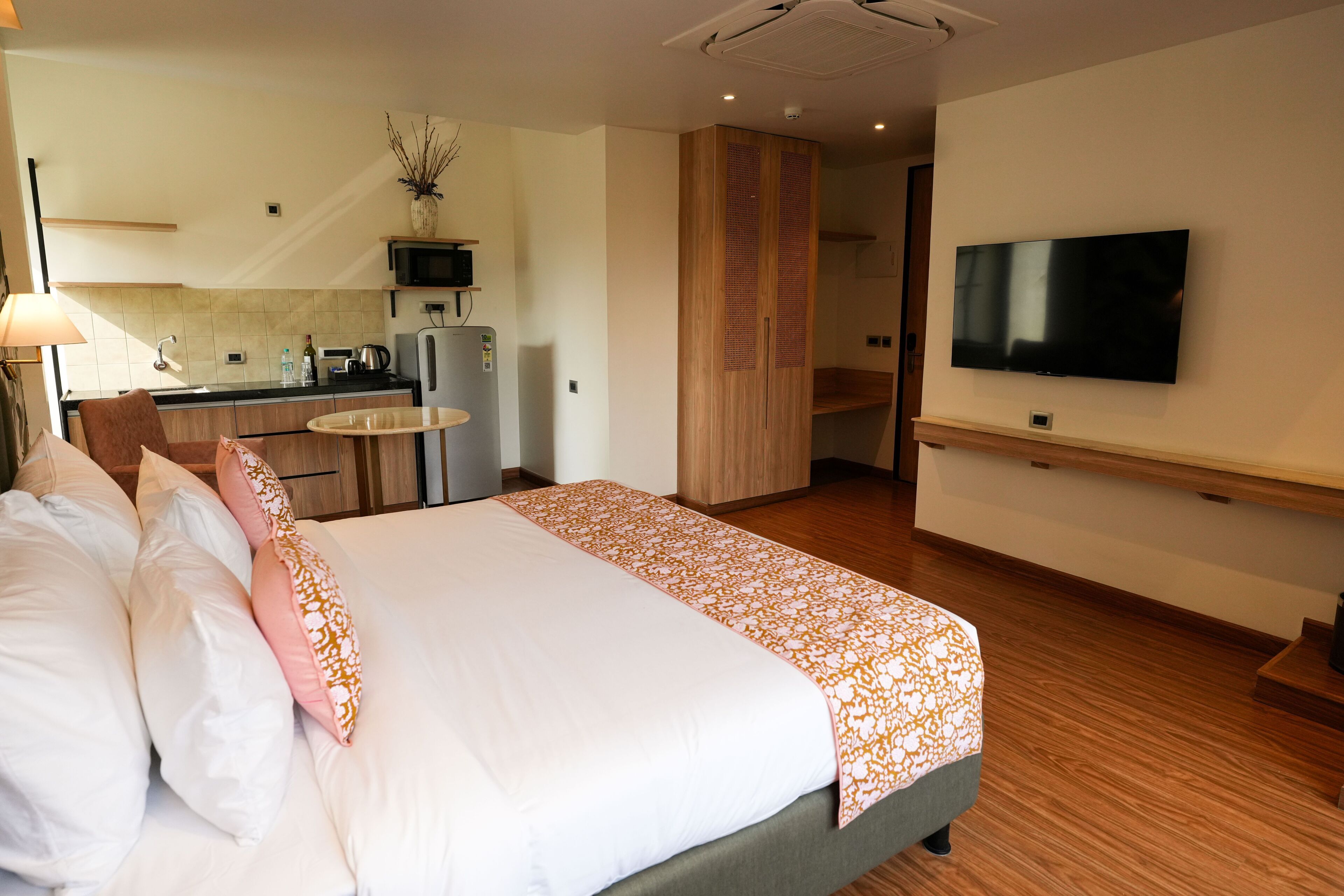 Une chambre d’hôtel comprenant un lit, une télévision, un coin cuisine et une table à manger.