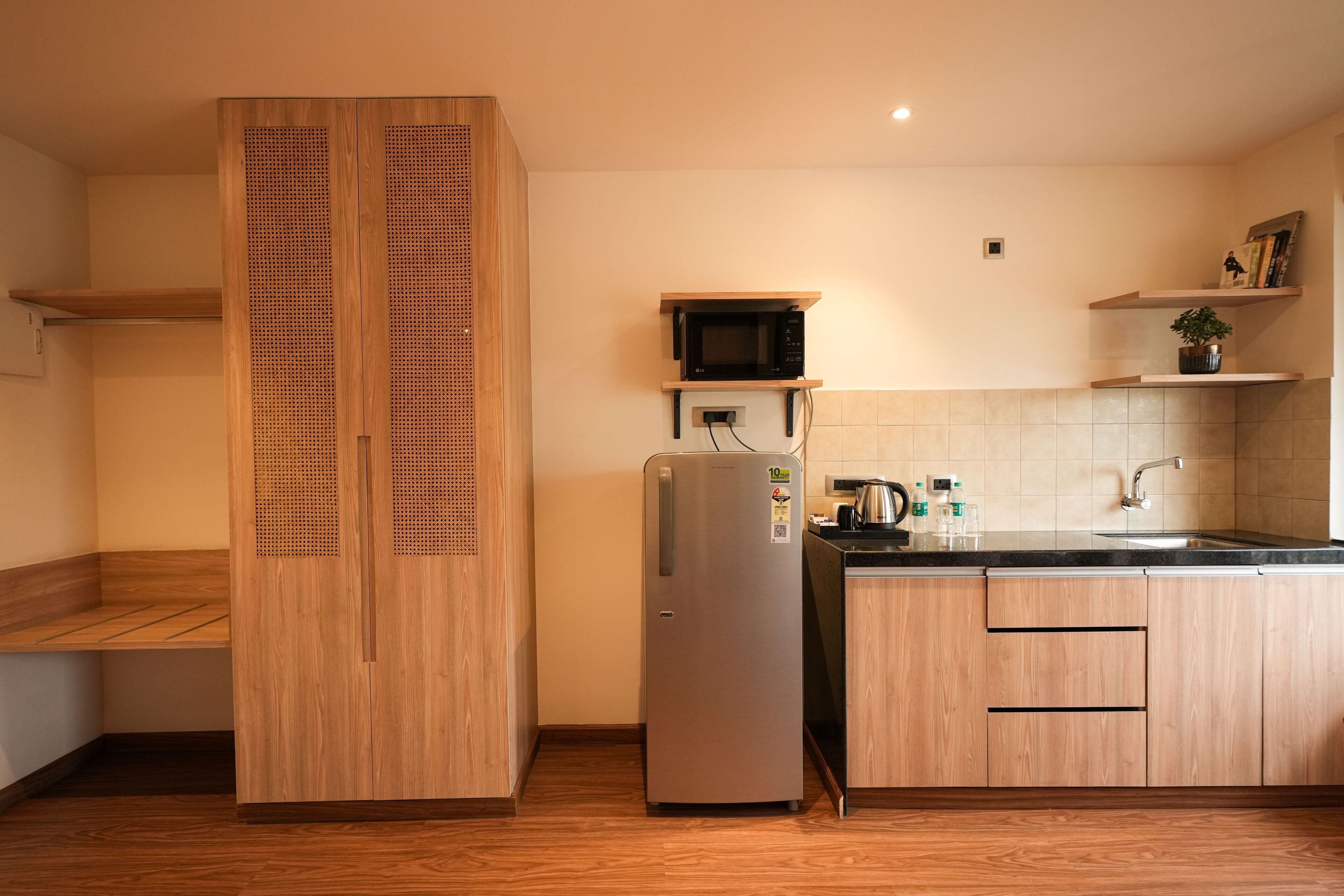 Une cuisine moderne avec des meubles en bois, un réfrigérateur en acier inoxydable, un four à micro-ondes et un évier.