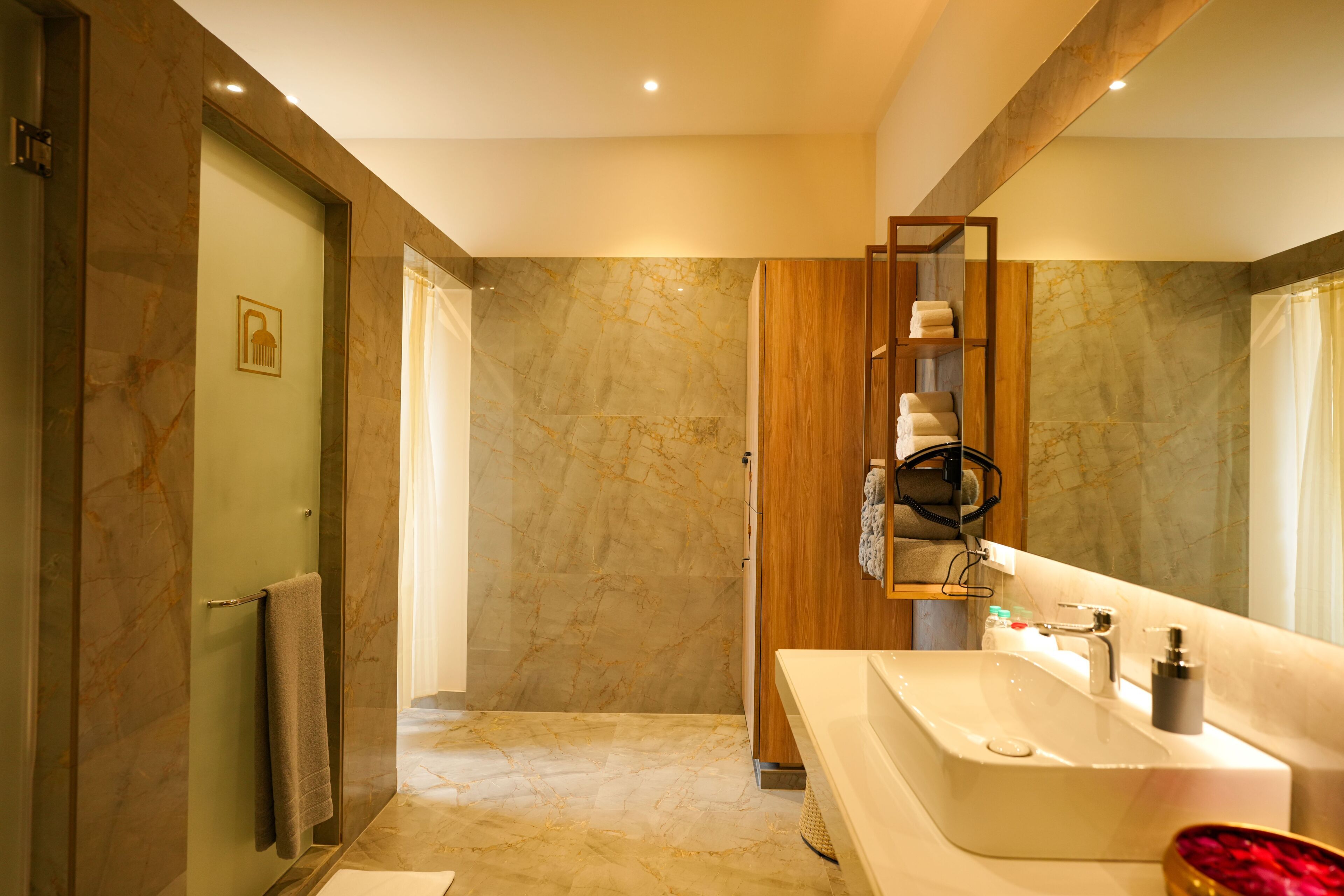 A modern bathroom with a marble floor, a large sink, and a wooden vanity.