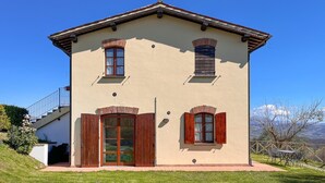 A two-story building with a beige facade, wooden shutters, and a balcony with a metal railing. - Amazing apartment in Gubbio with WiFi (Gubbio)