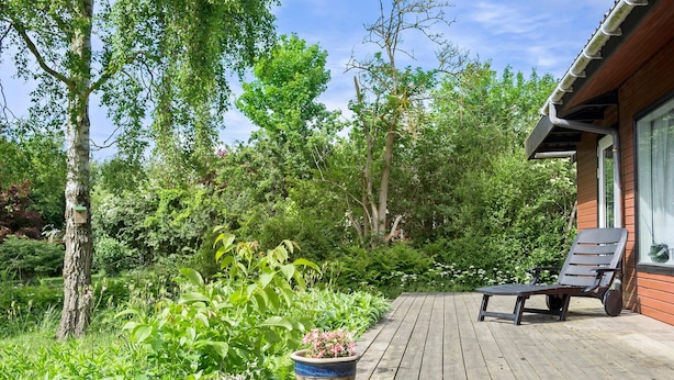 A wooden deck with a bench, surrounded by lush greenery and trees. - Awesome home in Jægerspris with WiFi (Jægerspris)