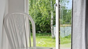 A white chair in a room with a view of a garden and a wooden fence. - Awesome home in Jægerspris with WiFi (Jægerspris)