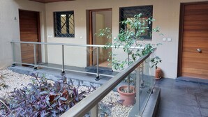 Un edificio moderno con un balcone, piante in vaso e pavimento piastrellato.