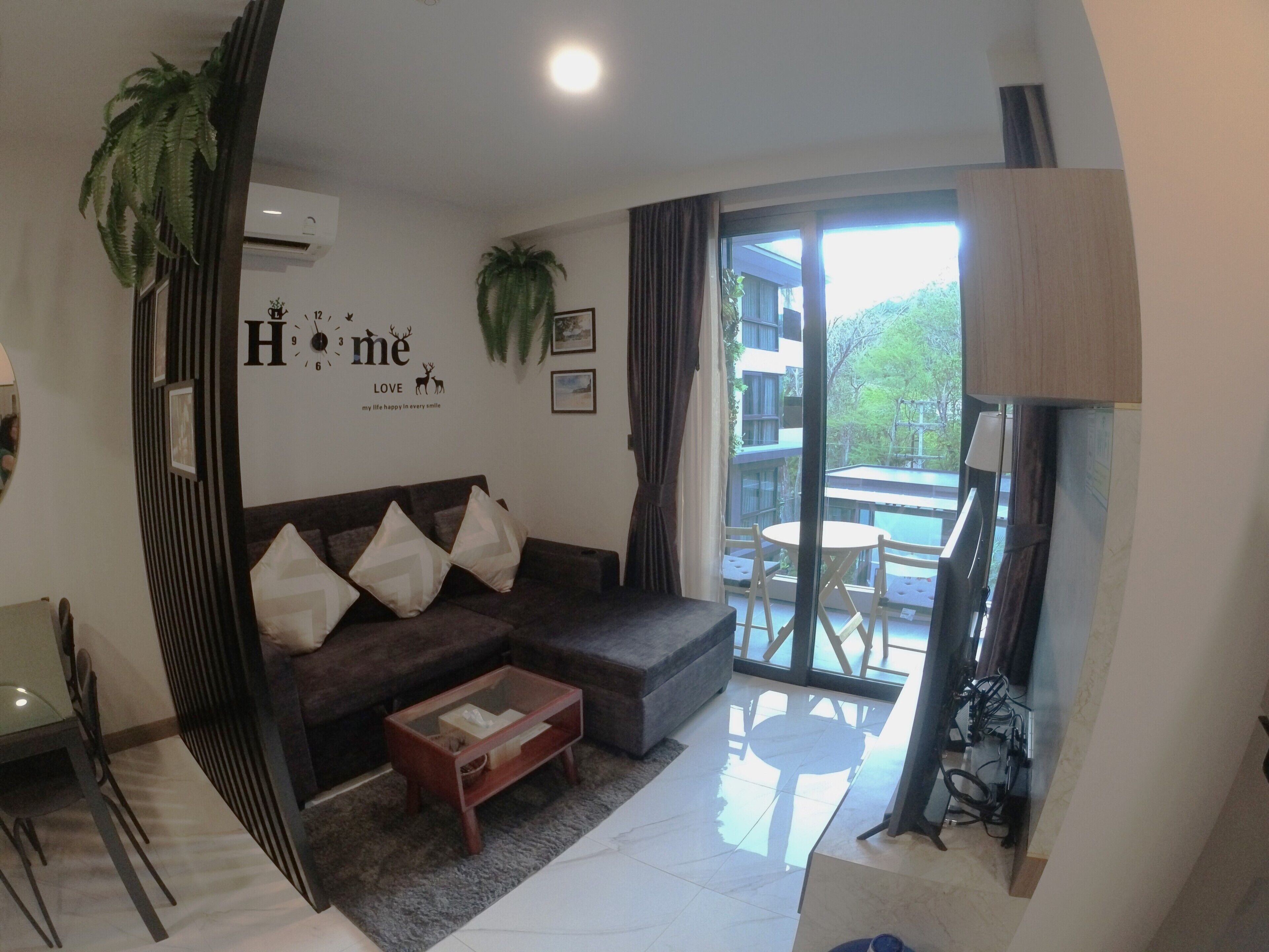 A modern living room with a sofa, coffee table, and a dining area with chairs.