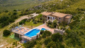 A Mediterranean-style villa with a swimming pool, surrounded by lush greenery and mountains in the background. - Cana Molí, ecohouse with sea views (Arta)
