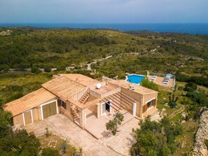 Eine Villa im mediterranen Stil mit Ziegeldach, Swimmingpool und Meerblick.