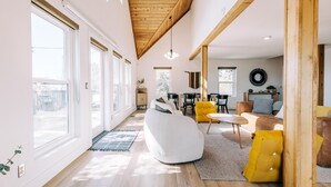 A spacious living room with a high ceiling, large windows, and a cozy seating area with a sofa and chairs. - Escape to Tranquility: Views & Modern Amenities (Idyllwild-Pine Cove)