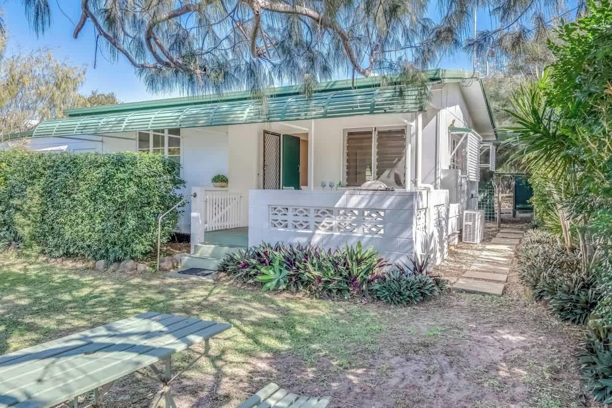 A house with a covered porch, a small garden, and a pathway leading to the entrance.