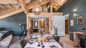 A dining area with a wooden ceiling, a chandelier, and a table set for six with plates, glasses, and cutlery. - L'ATTIQUE - brand new apartment for 10 people in the center of Chatel (CHATEL)