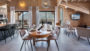 A spacious dining area with a large round table set for six, surrounded by modern chairs. - L'ATTIQUE - brand new apartment for 10 people in the center of Chatel (CHATEL)