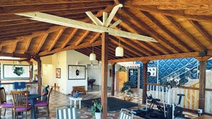 An open-plan space with a high wooden ceiling, a dining area with chairs and a table, a workout station, and a staircase leading to an upper level. - Hacienda Hotel Los Caballeros  (Marinilla)